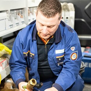 Der Handwerker konzentriert sich auf die Montage eines Wasserhahns, umgeben von verschiedenen Werkzeugen und Ausstattungen.