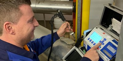Ein Techniker bedient ein Messgerät, während er konzentriert auf den Bildschirm schaut und eine Taste drückt.