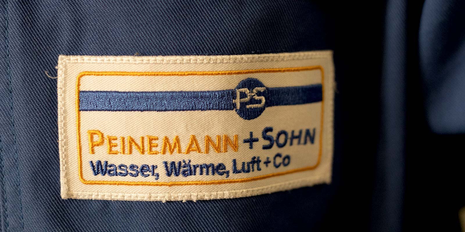 Das Etikett zeigt den Firmennamen 'Peinemann + Sohn' und die Dienstleistungen Wasser, Wärme, Luft und Co.