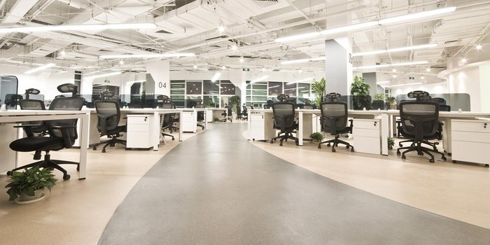 Ein minimalistisches Bürodesign mit vielen leeren Arbeitsplätzen, das eine ruhige und produktive Atmosphäre ausstrahlt.